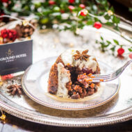 Festive dessert on a silver tray at Old Ground Hotel, with a hand holding a fork.