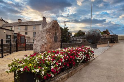 Vibrant flowers and sculptures at sunset near Old Ground Hotel, inviting serene experience.
