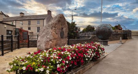 Vibrant flowers and sculptures at sunset near Old Ground Hotel, inviting serene experience.