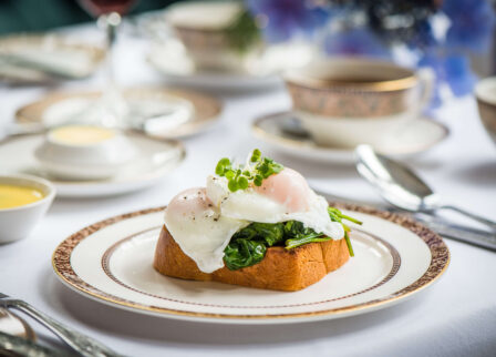 Elegant breakfast setting with poached eggs on toast at a cosy hotel restaurant.