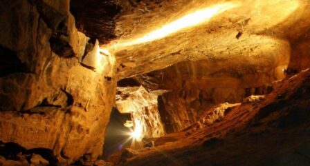A warm-lit cave with a family exploring, surrounded by stunning rock formations.