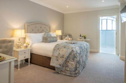 Cosy hotel room with a plush bed, warm lighting, and inviting decor, perfect for a relaxing stay.