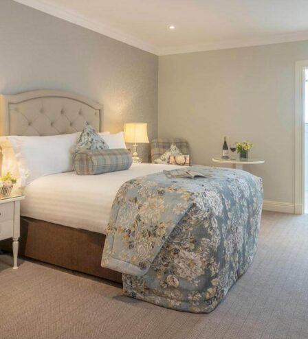 Cosy hotel room with a plush bed, warm lighting, and inviting decor, perfect for a relaxing stay.