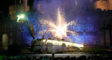 A family watches a lively night show with fireworks at a castle venue.