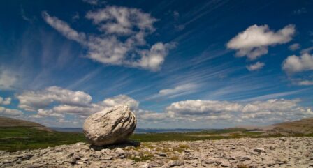 Stunning rocky landscape under a bright blue sky with wispy clouds, evoking peace and adventure.