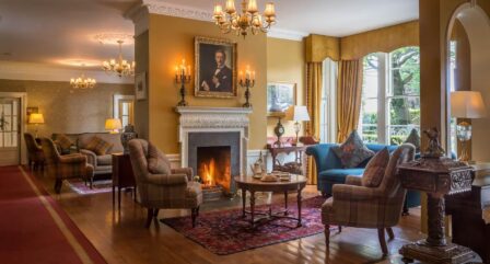 Cosy hotel lounge with a family enjoying tea by a fireplace, featuring elegant decor.