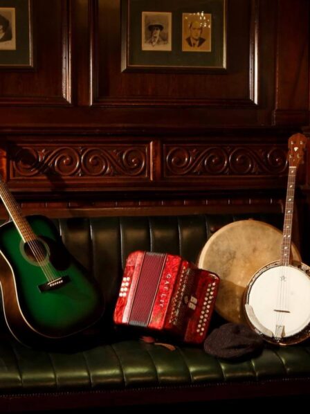 Warm, wooden lounge with guitar, banjo, and accordion on a green leather sofa at Old Ground Hotel.