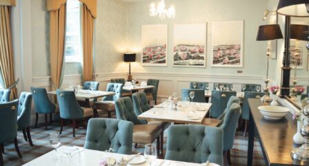 Elegant hotel dining room with tables set, ideal for family gatherings.